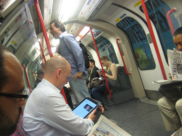 man looking at ipad on his commute
