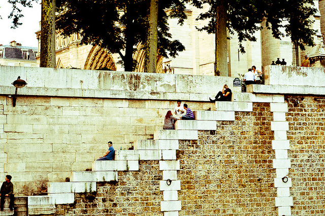 Parisians sitting on the steps leading down to the River Seine in Paris 