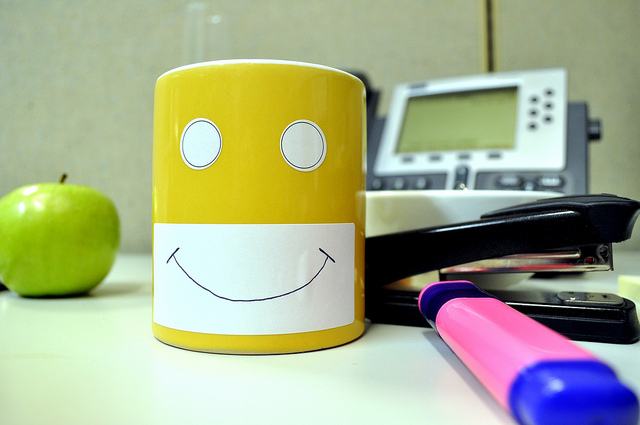 mug with a happy face on a desk