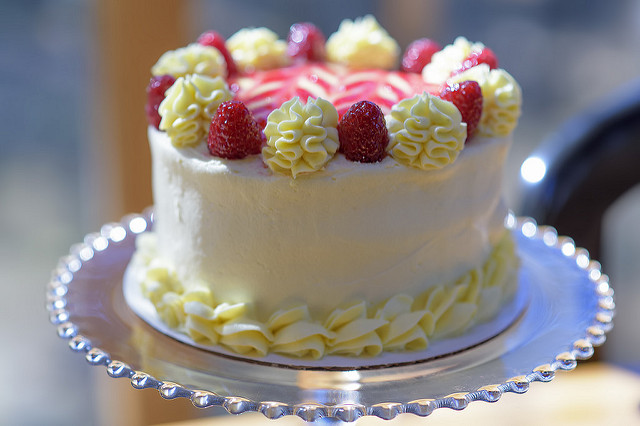 Close up of a frosted, iced cake with fruit