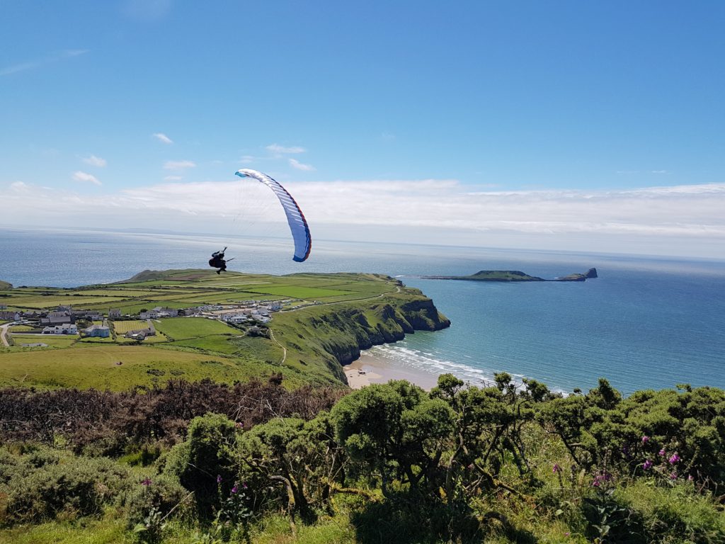 close up of paragliders above Rhossili Beach on the Gower Peninsula, South Wales