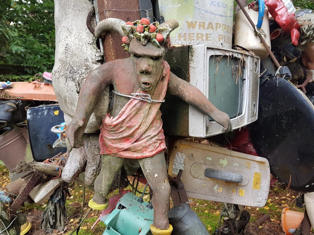 close up of an eco warrior in a mountain of household rubbish - just one of the sculptures at the Churt Sculpture Park, near Farnham 