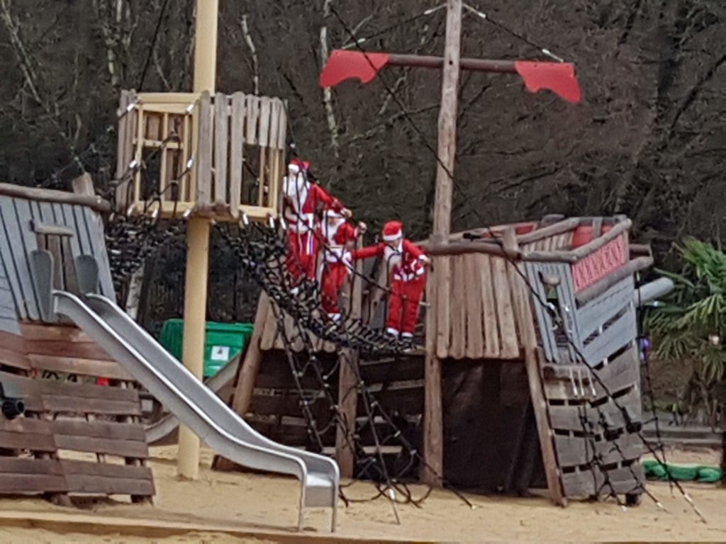 Young Santa Dash runners playing on a pirate ship