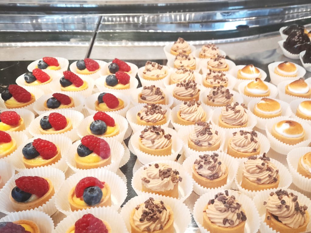 rows of tiny cakes on display at eataly london